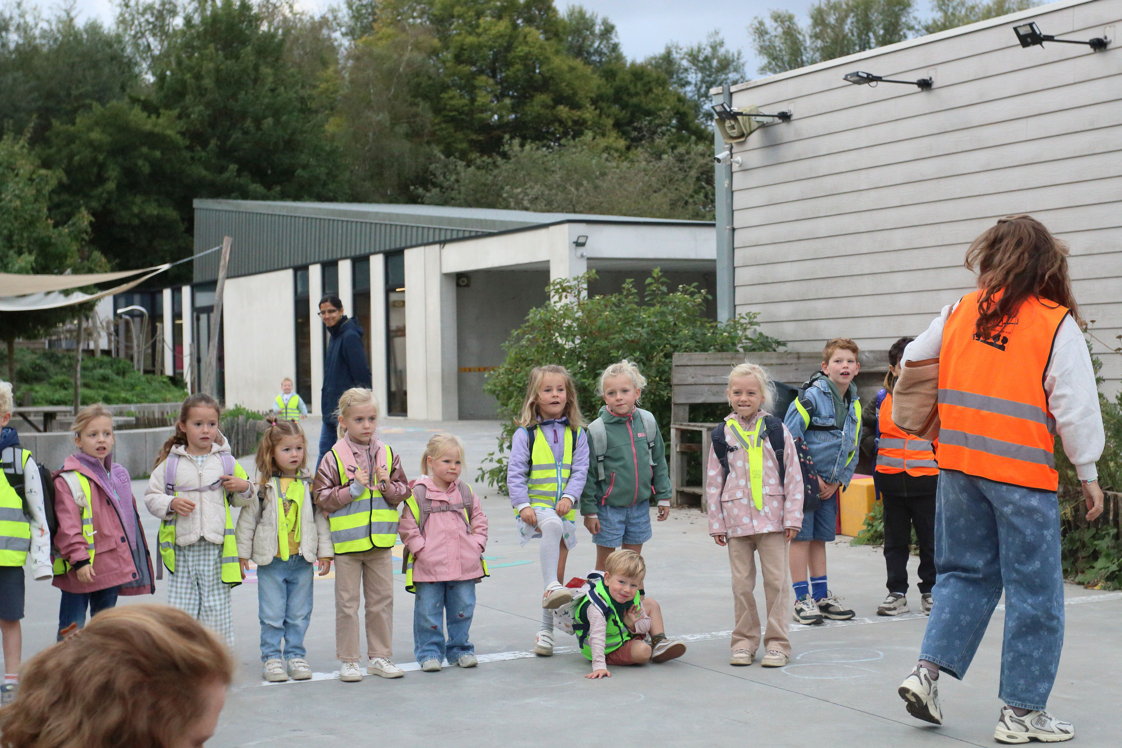 Klas met fluohesjes op de speelplaats
